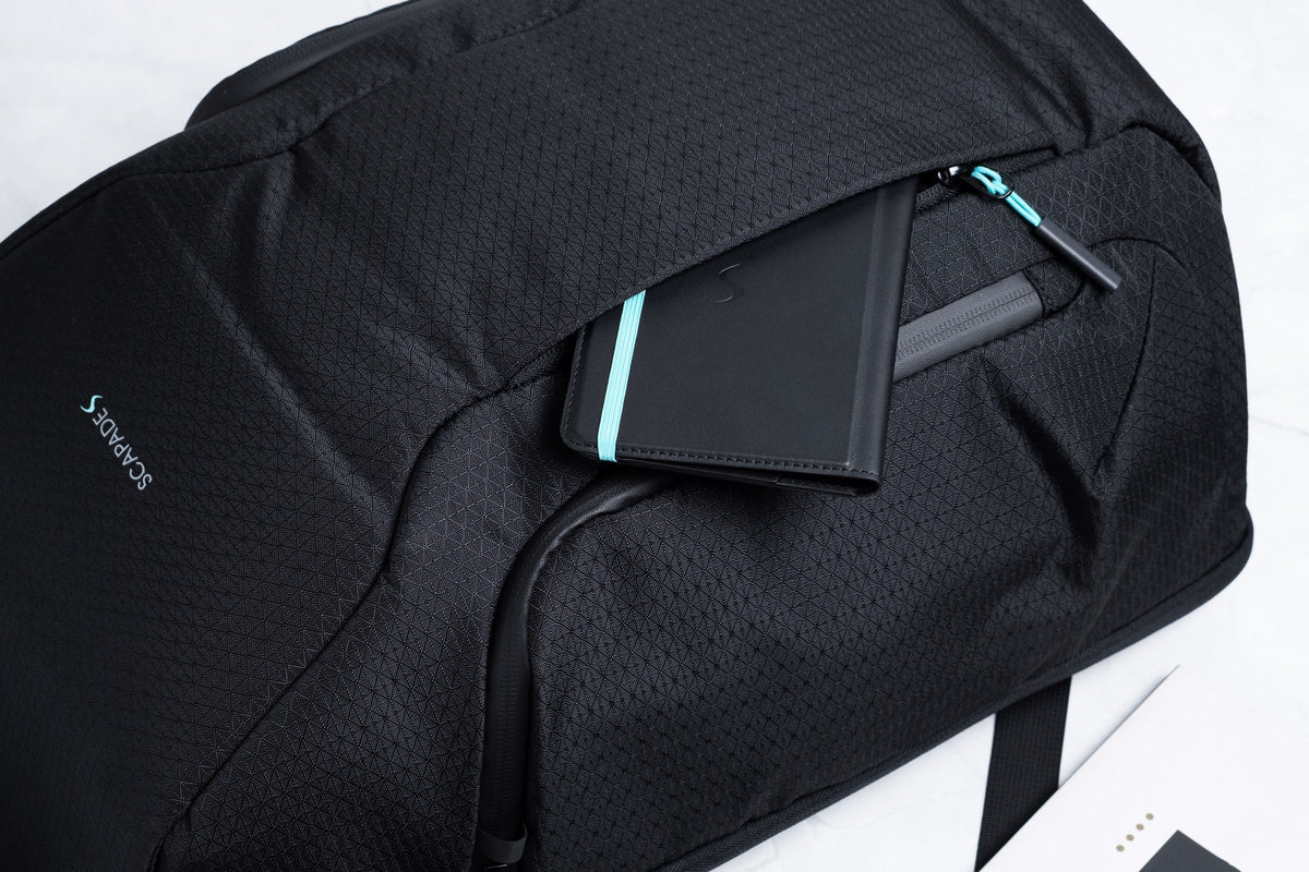Black Scapade AirPack backpack with the AirPass passport wallet tucked into its front pocket