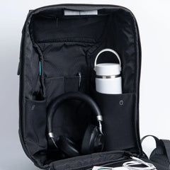 Scapade AirPack open, with pockets holding headphones, a water bottle and cables